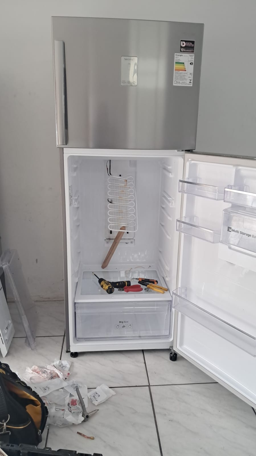 Técnico consertando geladeira