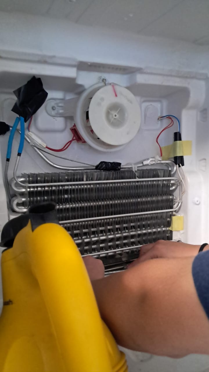 Técnico consertando geladeira