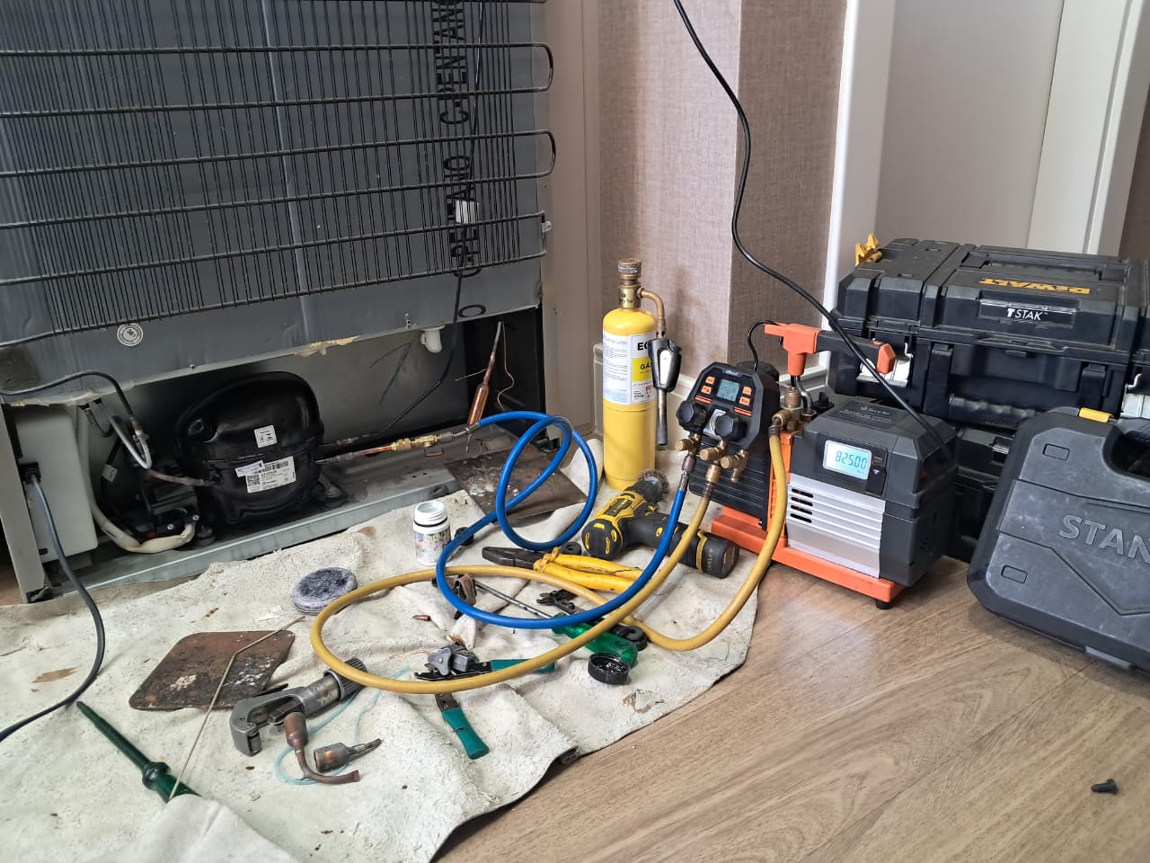 Técnico consertando geladeira