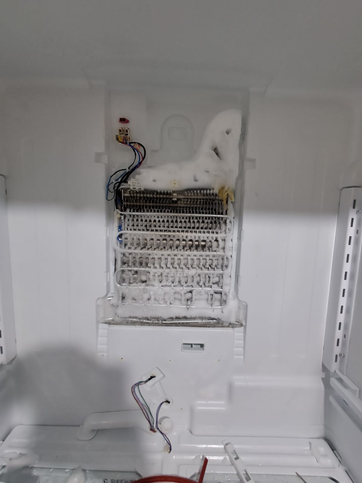 Técnico consertando geladeira